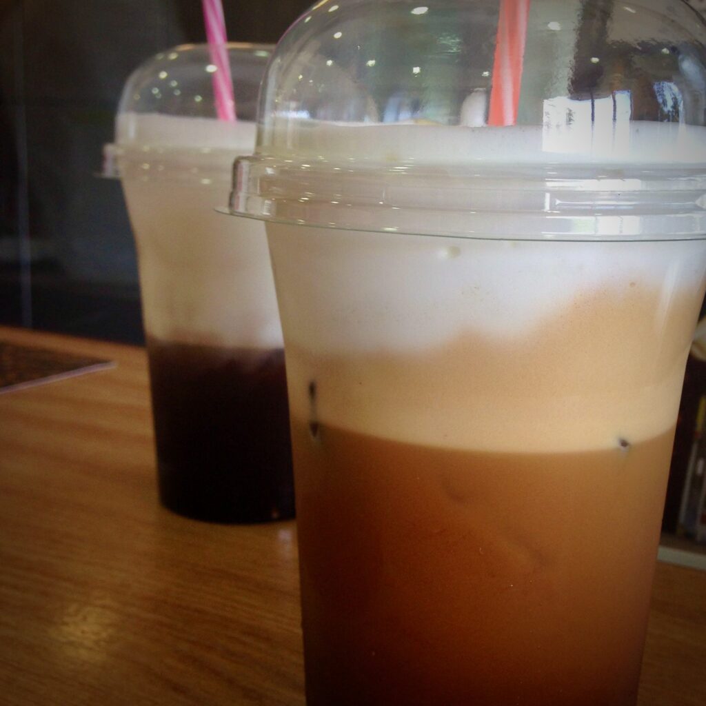 Frappe coffee in plastic cups and straws