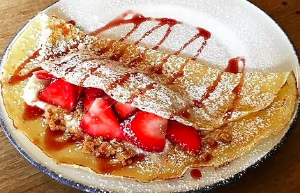 Strawberry crepes with maple syrup and icing sugar