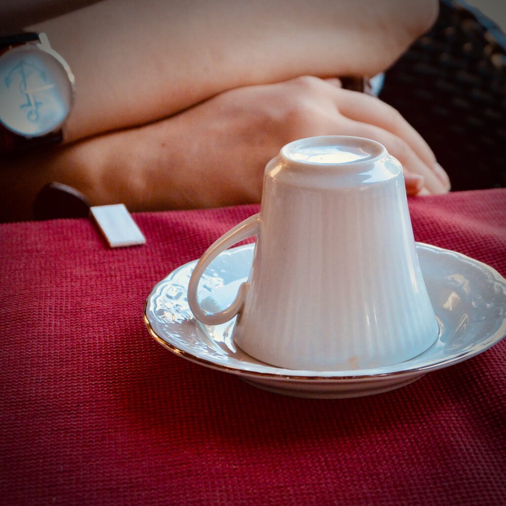 White tea cup upside down on it's saucer on a red table cloth