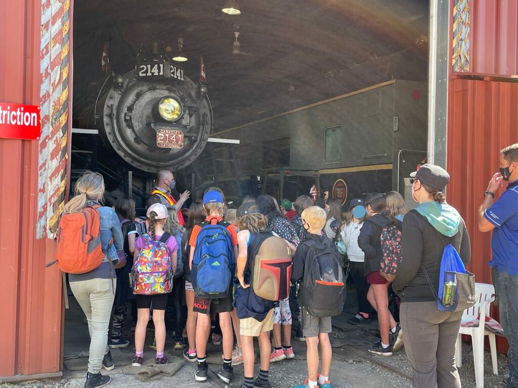 A group of elementary students take a tour of the backshop (photographer unknown, retrieved from Kamloops Heritage Railway FaceBook page). 
