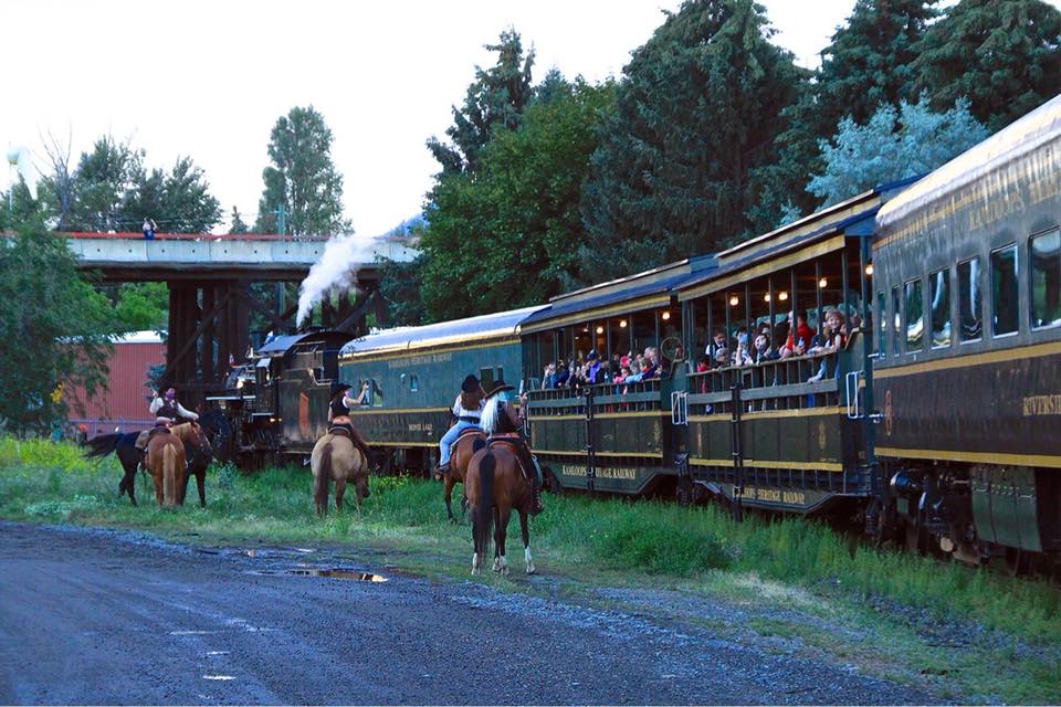 Train robbers on horseback (actors) firing pistols